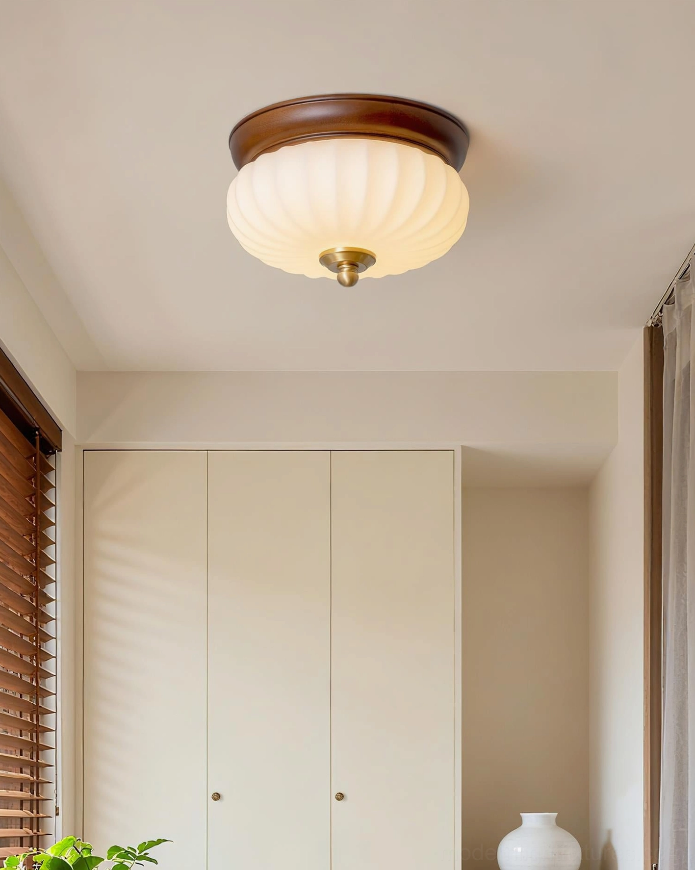Brioche ribbed glass lamp mounted on ceiling in minimalist dining nook with wood cap and brass accents