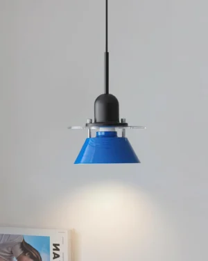 Contemporary blue pendant lamp installed in modern interior with magazine and light gray wall background