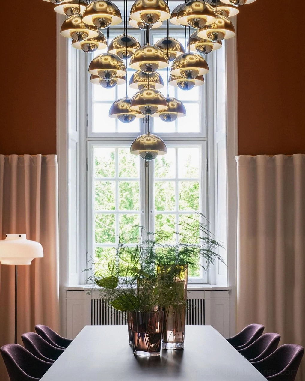 Golden bronze metallic dome pendant chandelier in formal dining space with tiered clustered metal shades creating sophisticated ambiance