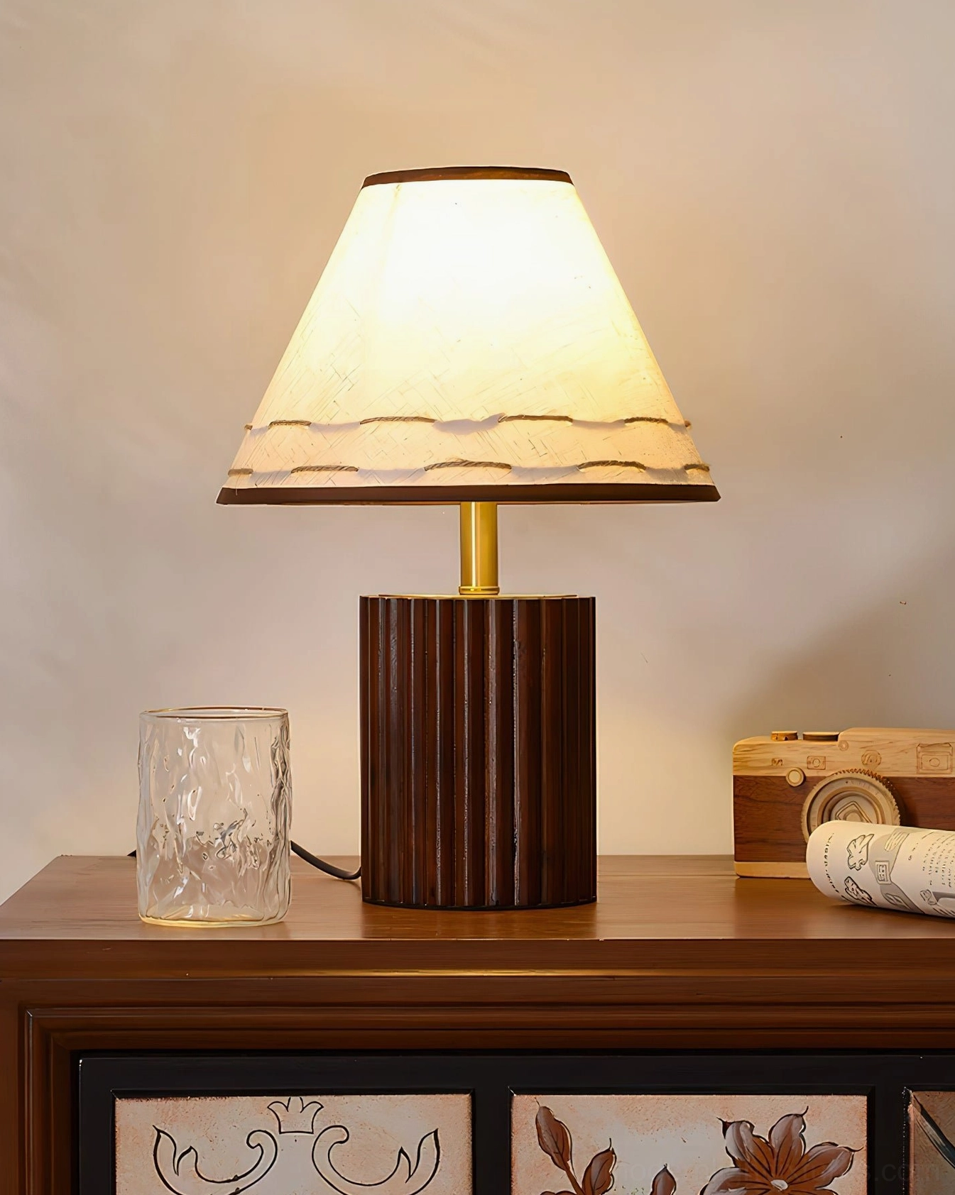 Wooden bedside lamp with walnut fluted base on retro wooden side table with floral decoration and vintage accessories