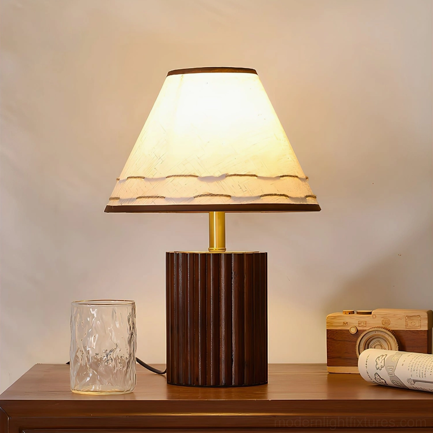 Natural wood table lamp with fluted cylindrical base on vintage wooden side table with decorative props