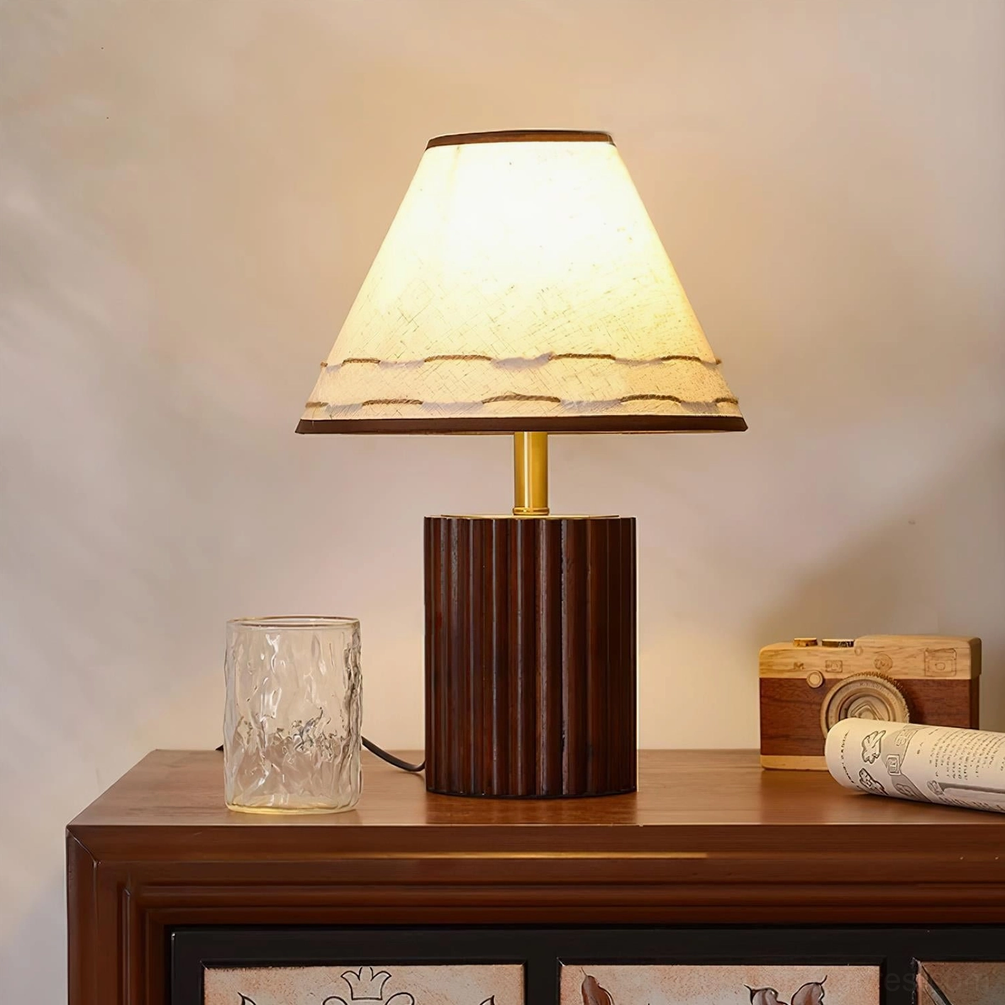 Handcrafted wooden table lamp with walnut finish base displayed on vintage wooden side table with glass cup and camera decor