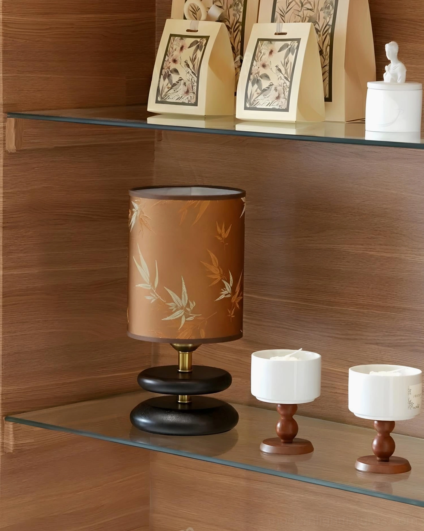 Brown bamboo-pattern table lamp displayed on glass shelf with decorative items, eye-level front view