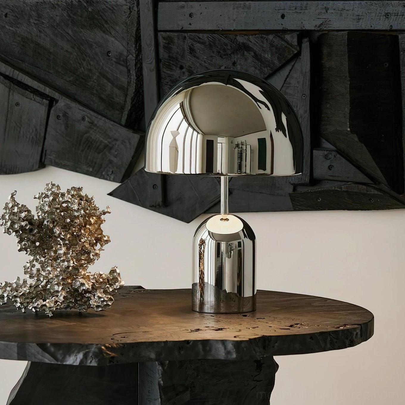Chrome Brulee modern table lamp beside metal decorative sculpture on rustic wooden side table