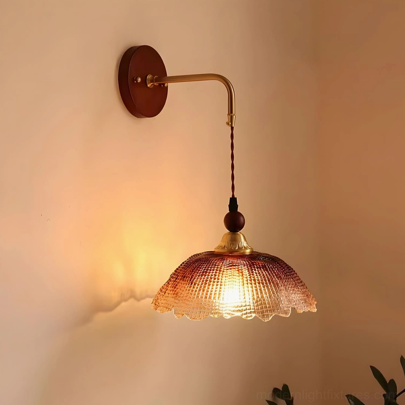 Bruma wall sconce lit up emitting warm ambient glow on textured glass shade