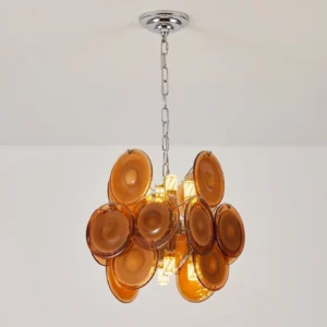 Illuminated amber glass disc pendant chandelier three-quarter view, showcasing interior light diffusion through translucent glass