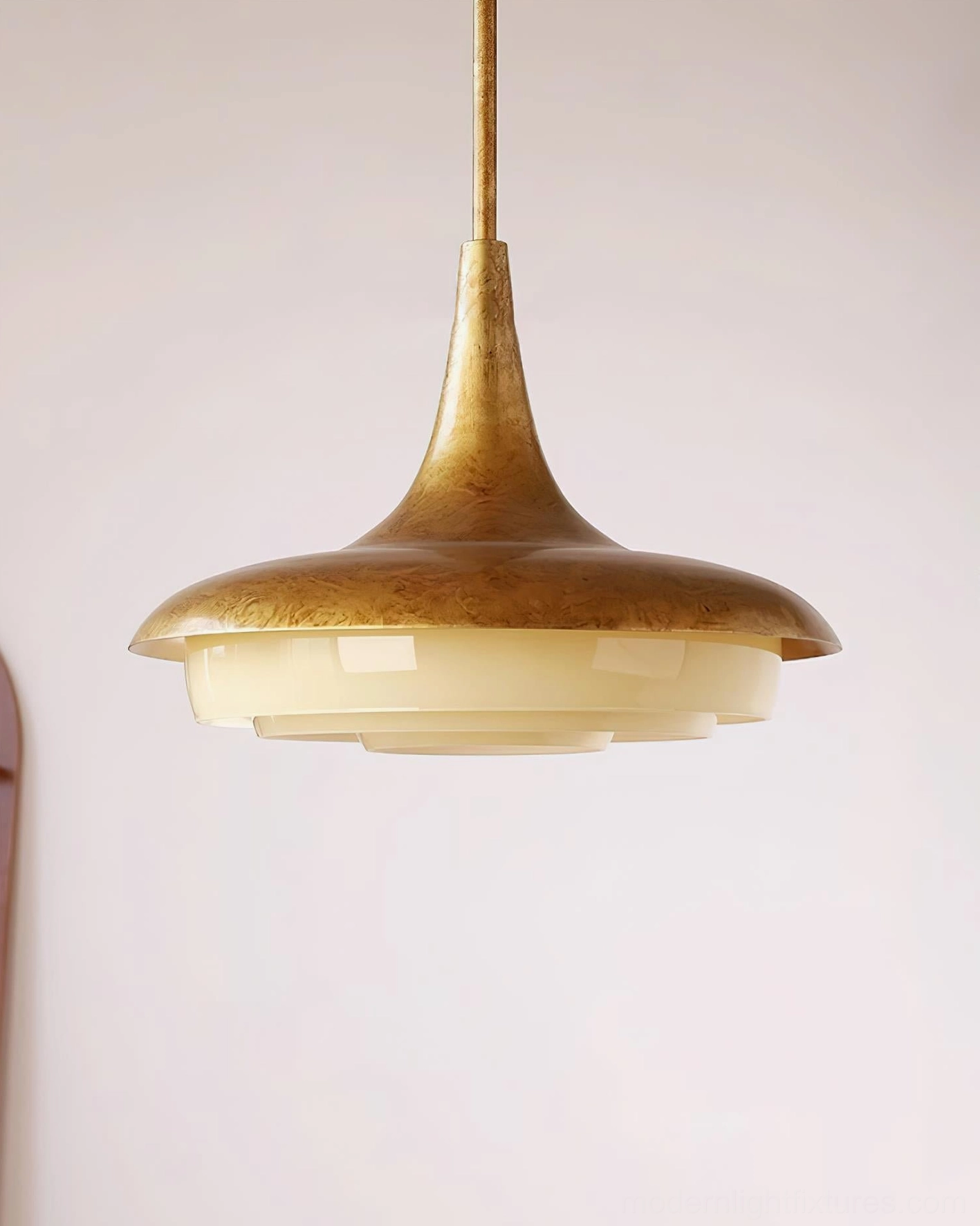 Brushed aged brass pendant light with layered glass interior, side overhead architectural view