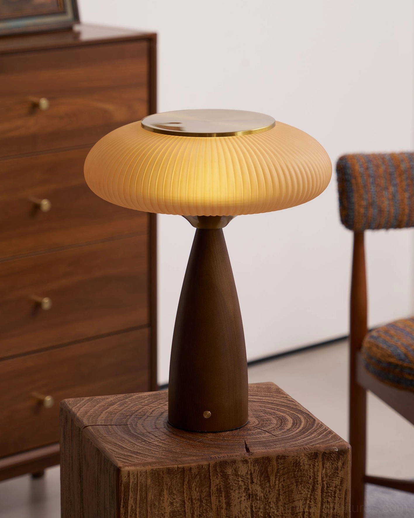 Brynn cordless table lamp on wooden pedestal with walnut dresser and upholstered chair, rustic home interior three-quarter view