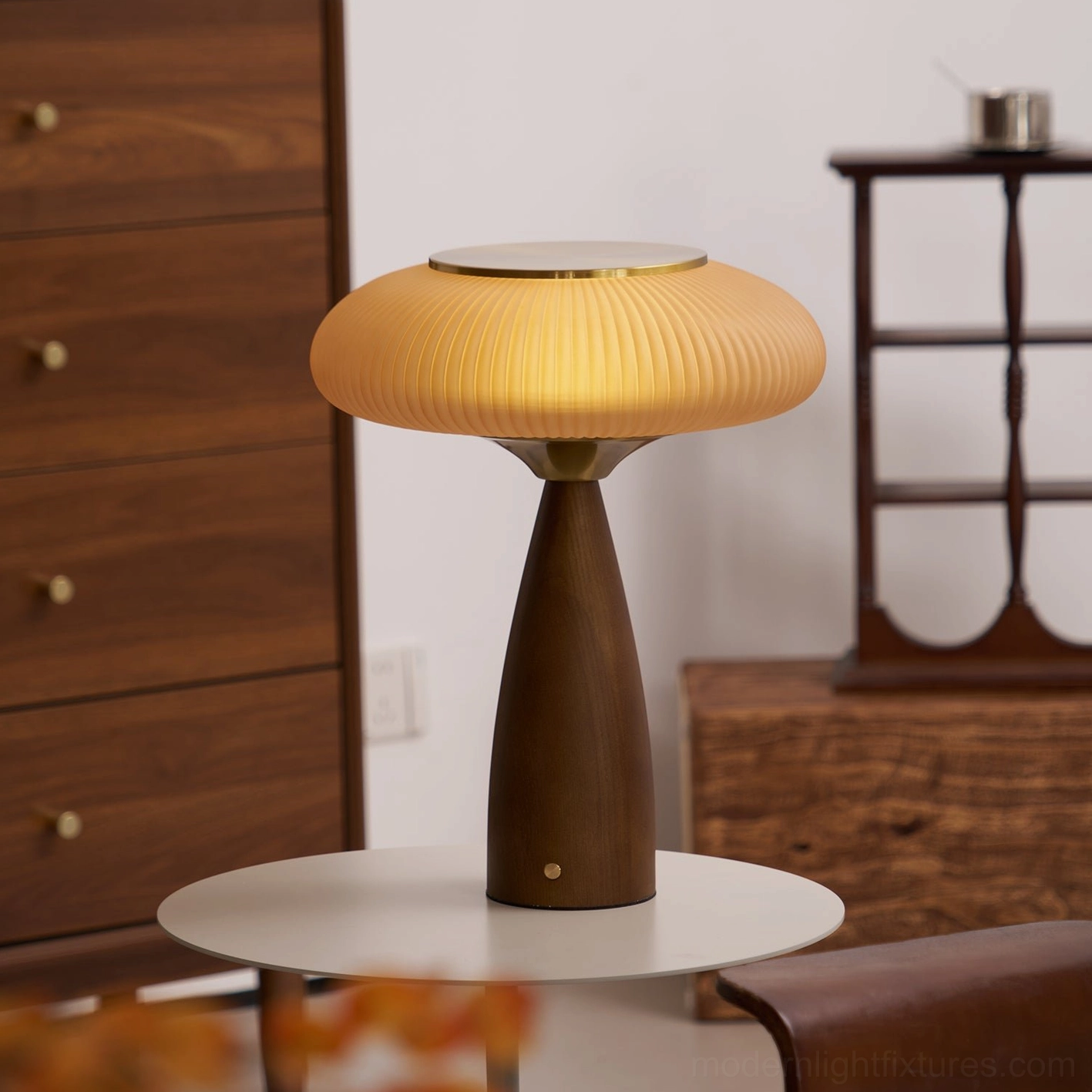 Brynn cordless table lamp displayed on round side table in retro home interior with walnut furniture, three-quarter front angle