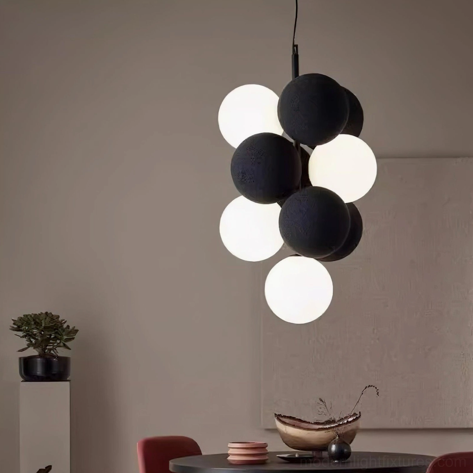 Front interior view of asymmetrical bubble pendant light in small dining area with black gray matte spheres