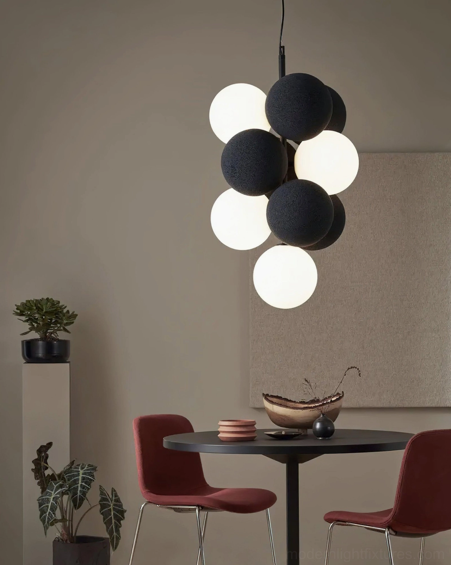 Side view of bubble pendant light over small dining corner with black gray off-white spherical shades