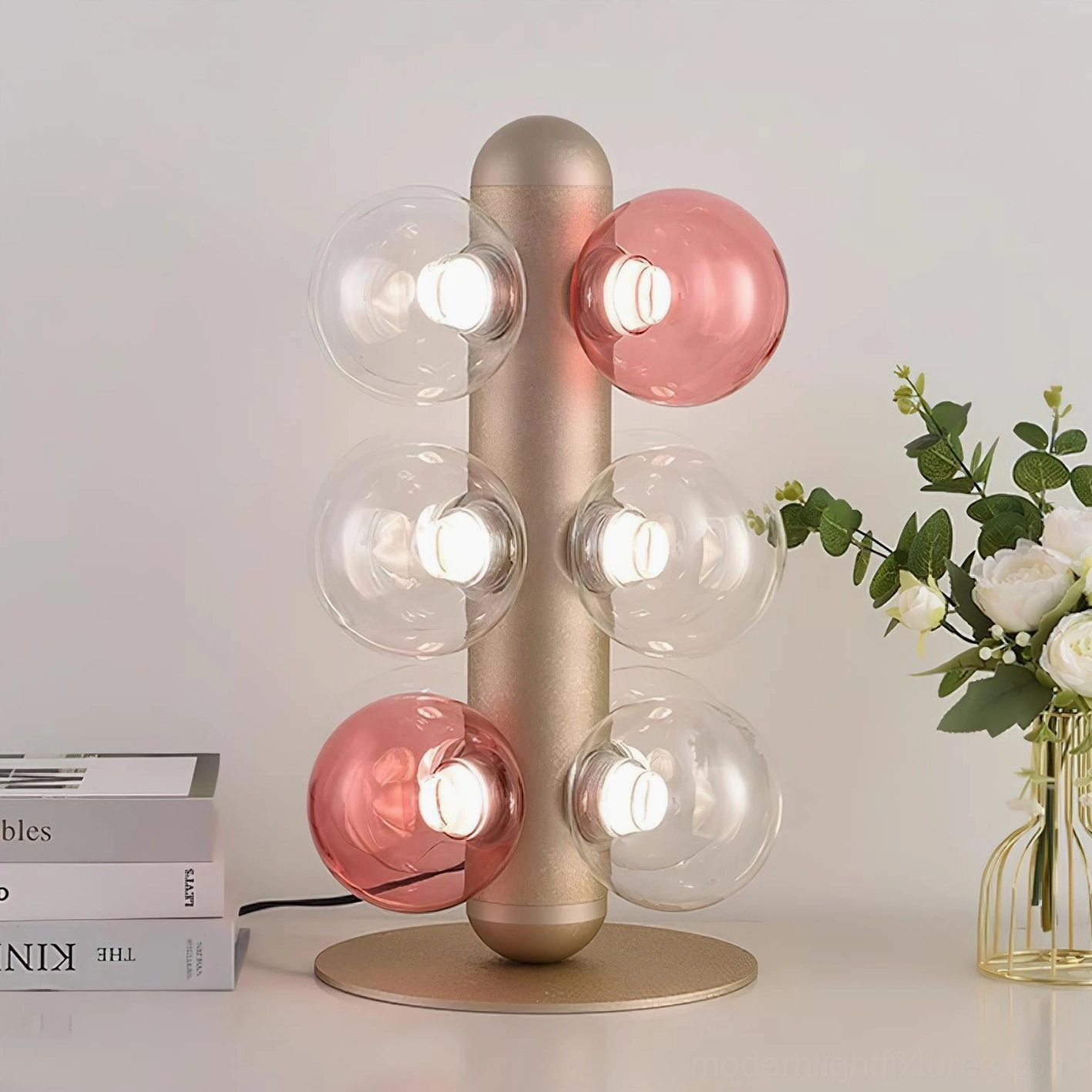 Modern glass bubble table lamp on tabletop with books and flowers, warm glowing ambient lighting, luxury home décor