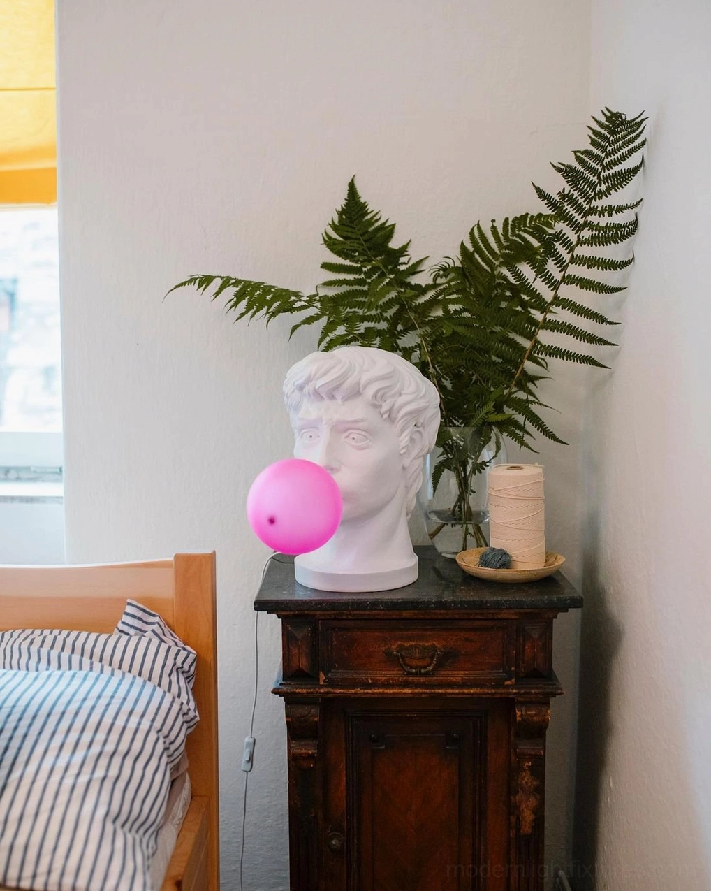 Bubblegum Boy sculptural resin table lamp with warm ambient lighting creating cozy bedroom atmosphere