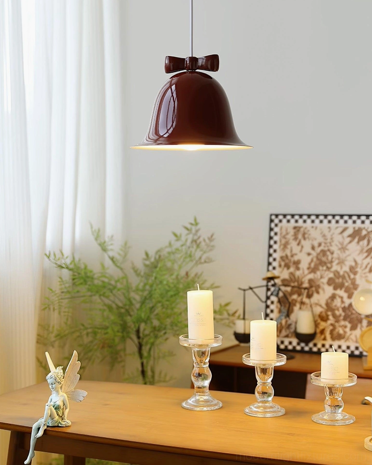 Burgundy red bell pendant lamp hanging above dining table with candles and fresh greenery
