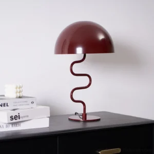 Burgundy Twist Table Lamp three-quarter view on black bedside table with books, modern desk lamp with dome shade