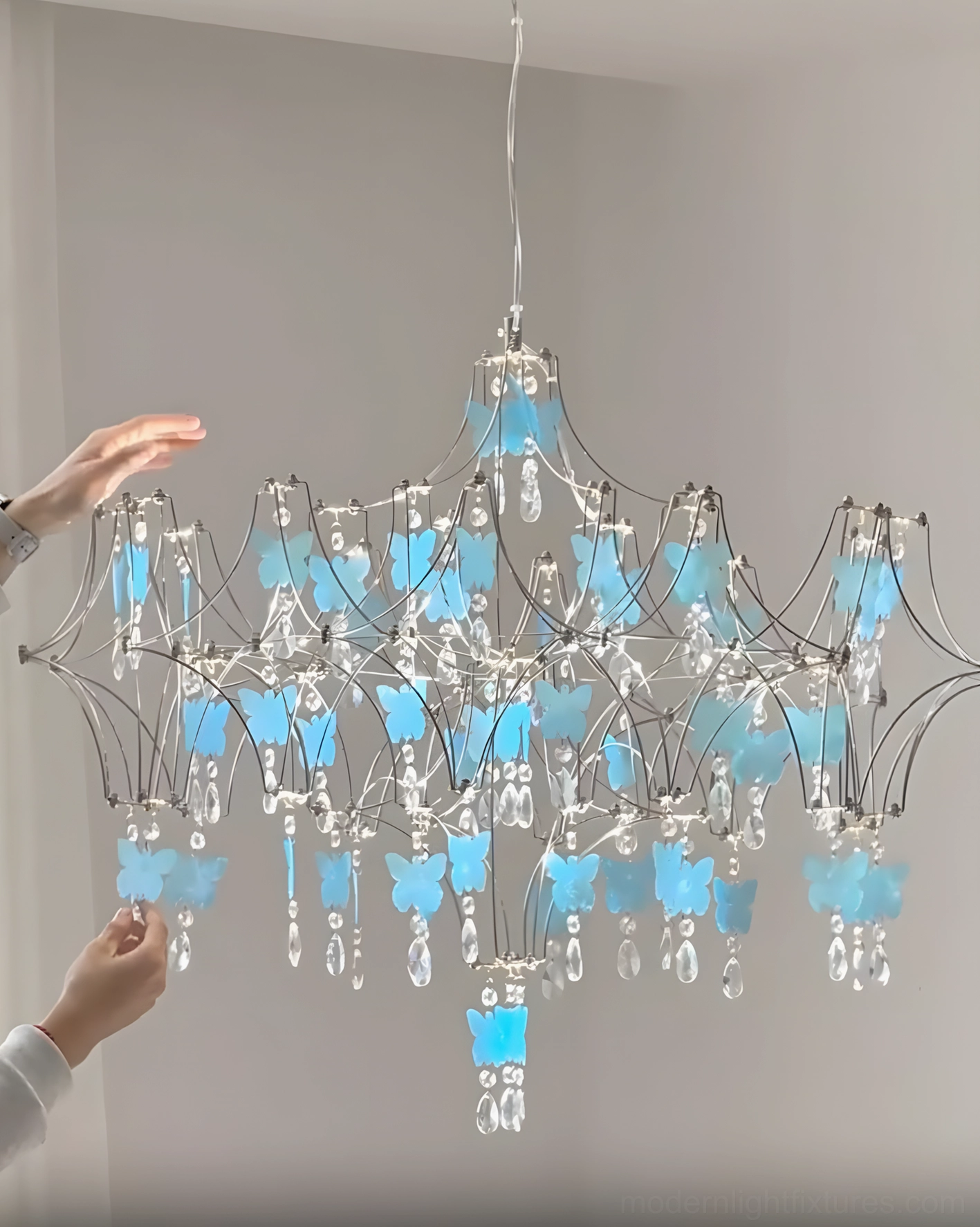 Close-up detail of butterfly dream chandelier showing handcrafted butterfly elements with shimmering crystal droplets and metal frame construction quality