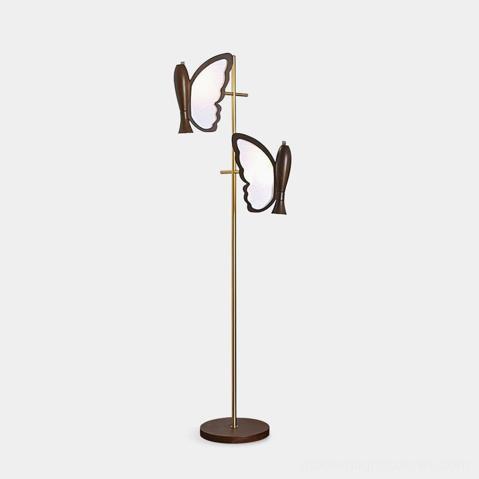 Butterfly floor lamp with dual butterfly-shaped lamp heads, brass gold metal stand, dark wooden base, front three-quarter view