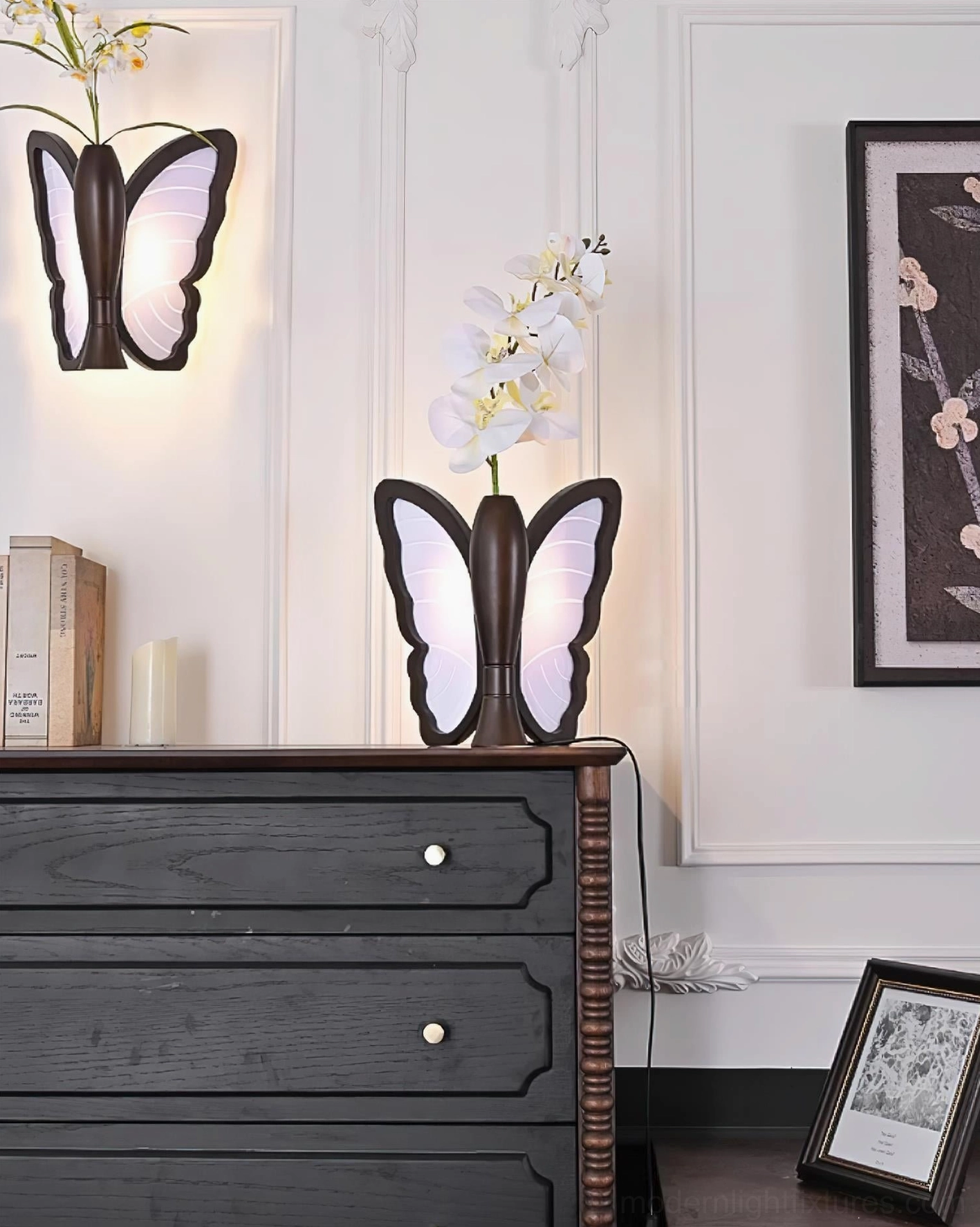 Butterfly table lamp and wall-mounted butterfly lamp together in bedroom with candle decor on dresser