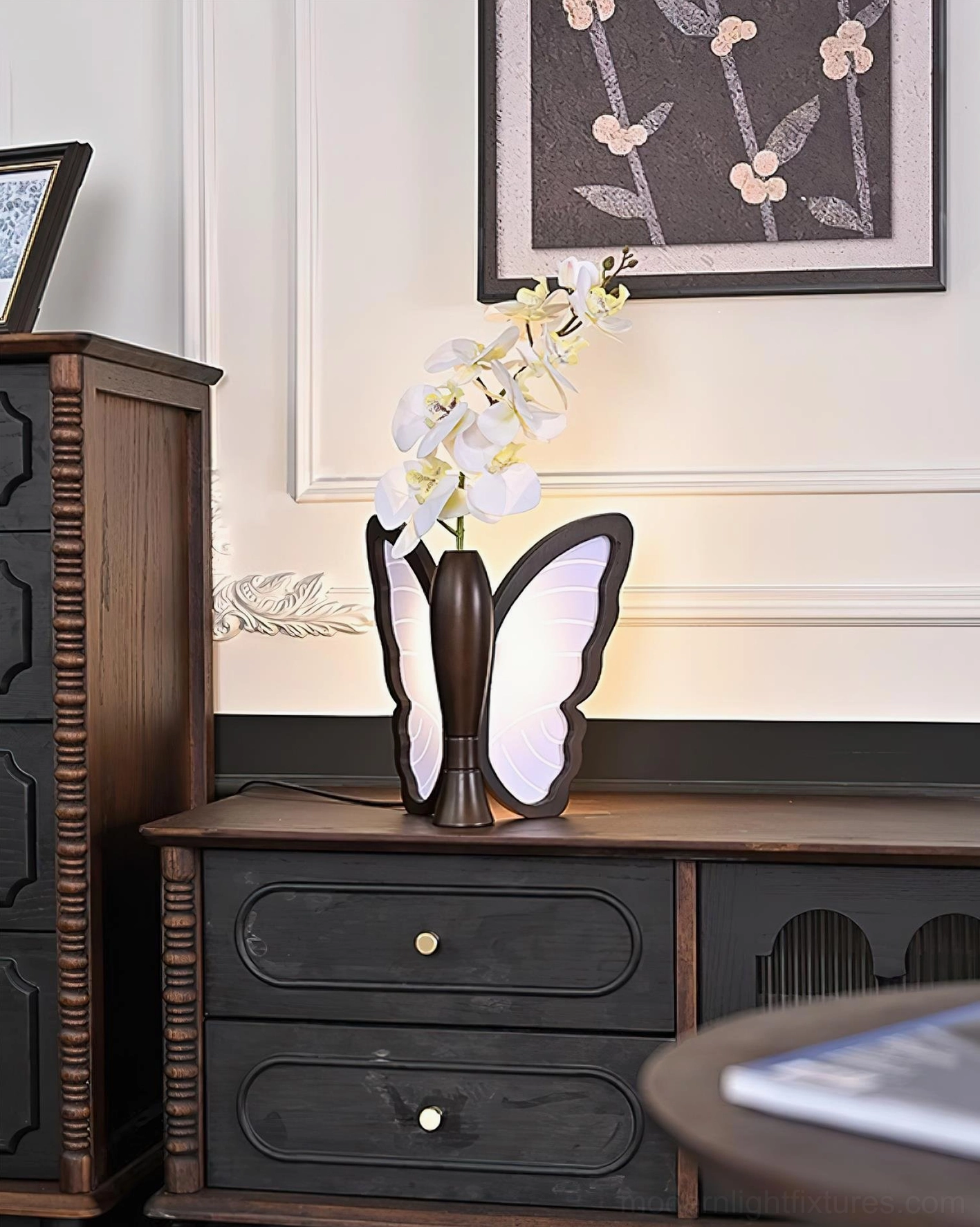 Butterfly table lamp styled with orchid flowers on vintage console table, warm lighting ambiance