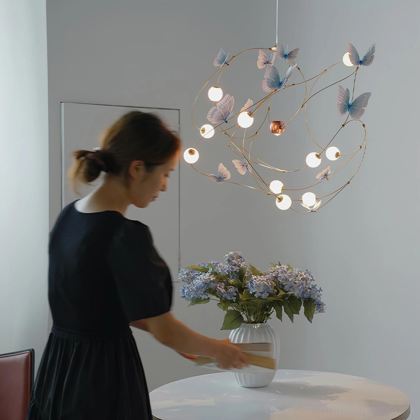 Contemporary pendant fixture with butterfly-inspired brass curves and warm LED illumination for dining room ambiance