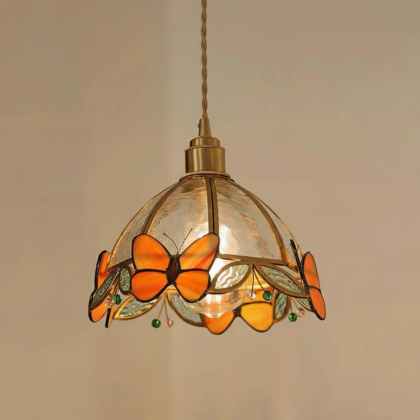 Orange butterfly stained glass pendant lamp featuring brass accents and decorative glass beads with exposed bulb