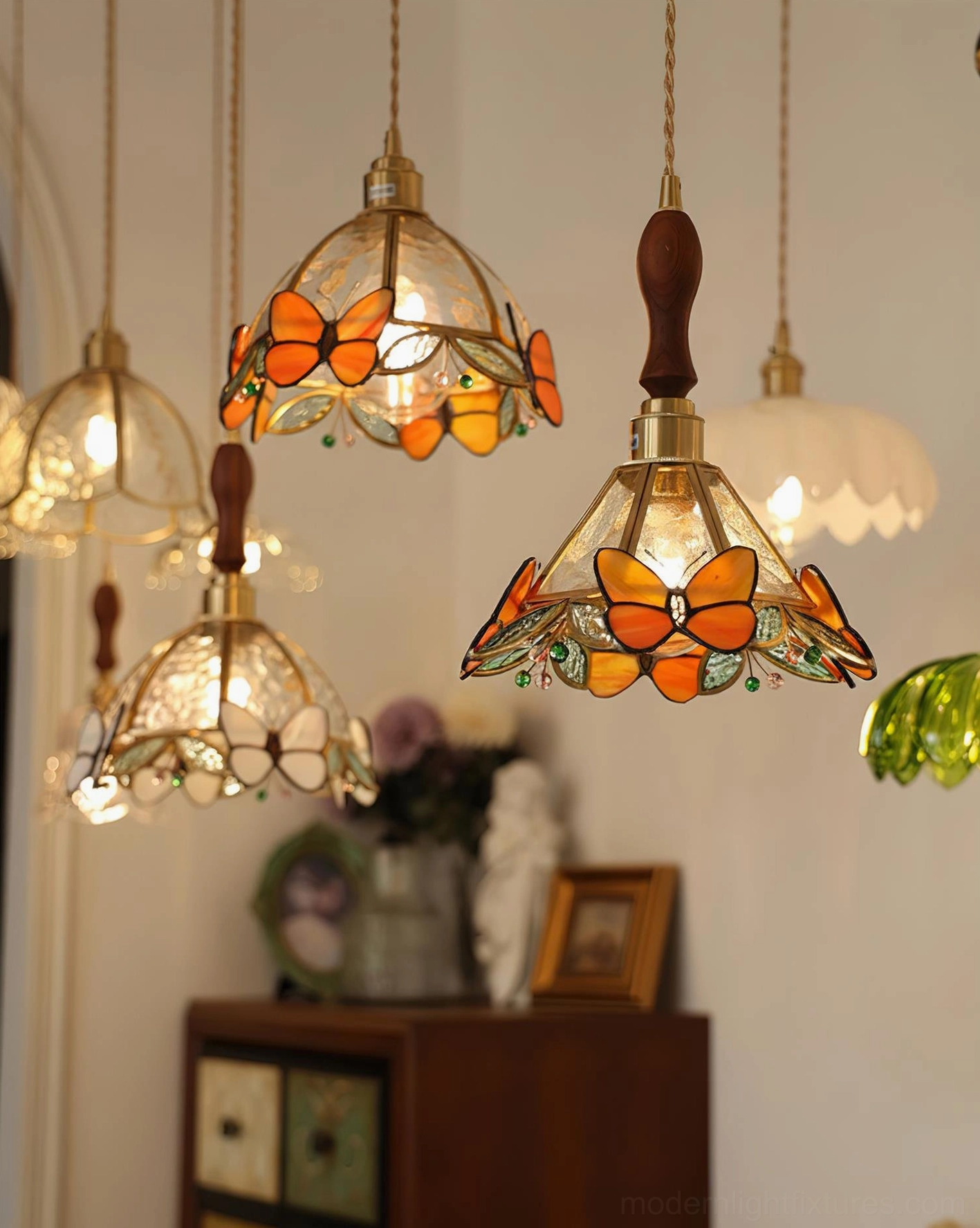Multiple handcrafted butterfly pendant lamps in assorted jewel tones displayed in vintage home decor setting