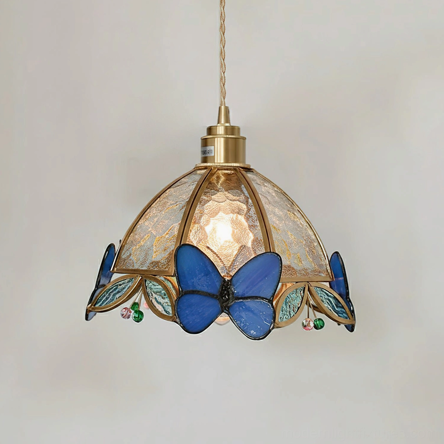 Blue butterfly stained glass pendant lamp displaying intricate glass butterflies and warm brass accents