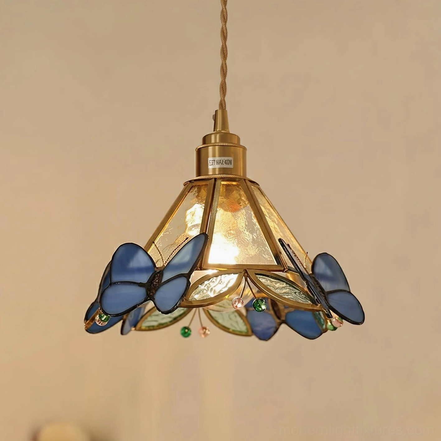 Blue handcrafted butterfly stained glass pendant lamp with brass hardware in close-up view