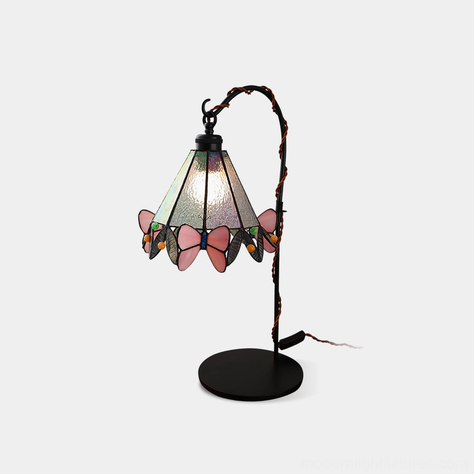 Front view of stained glass butterfly table lamp with black vine-inspired metal stand on white background