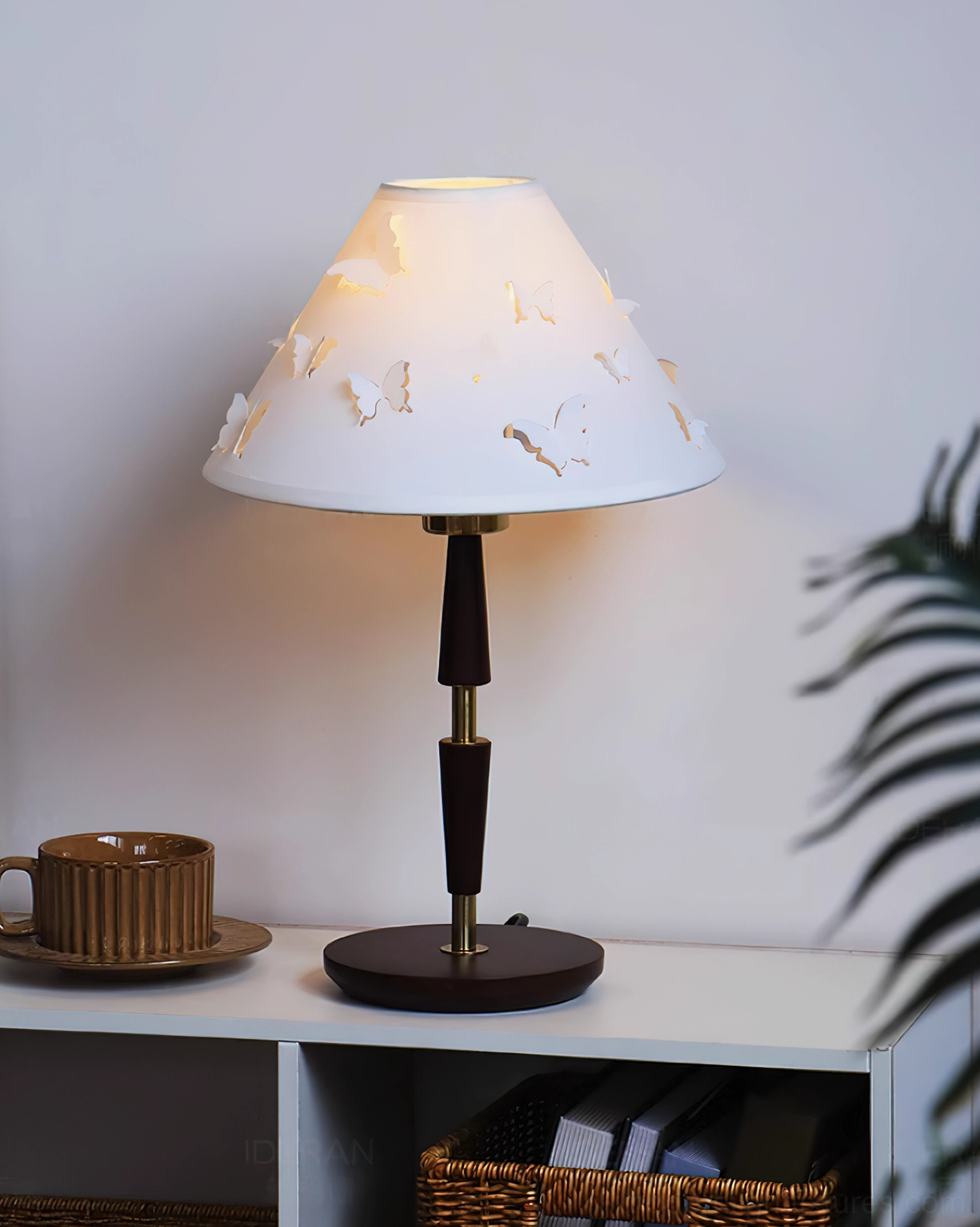 Contemporary butterfly table lamp on white side table with plant decor and coffee set styling