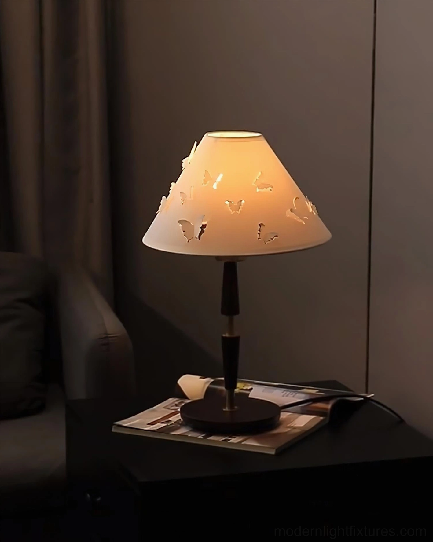 Illuminated butterfly table lamp casting soft ambient light in dark living room evening lighting
