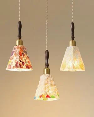 Close-up studio view of Cabana coastal pendant lights with dark wood accents, brass metal collars and twisted rope cords