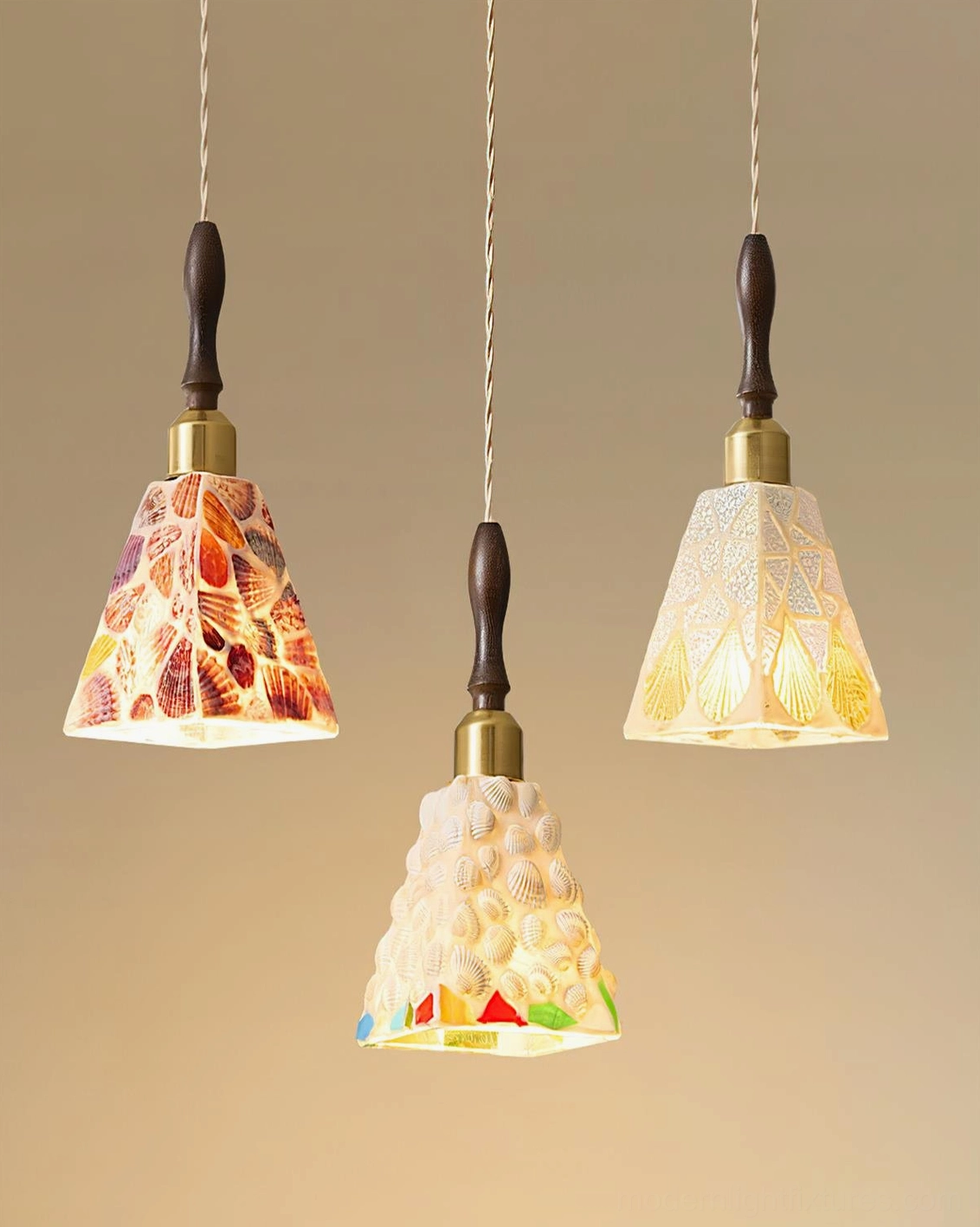 Close-up studio view of Cabana coastal pendant lights with dark wood accents, brass metal collars and twisted rope cords