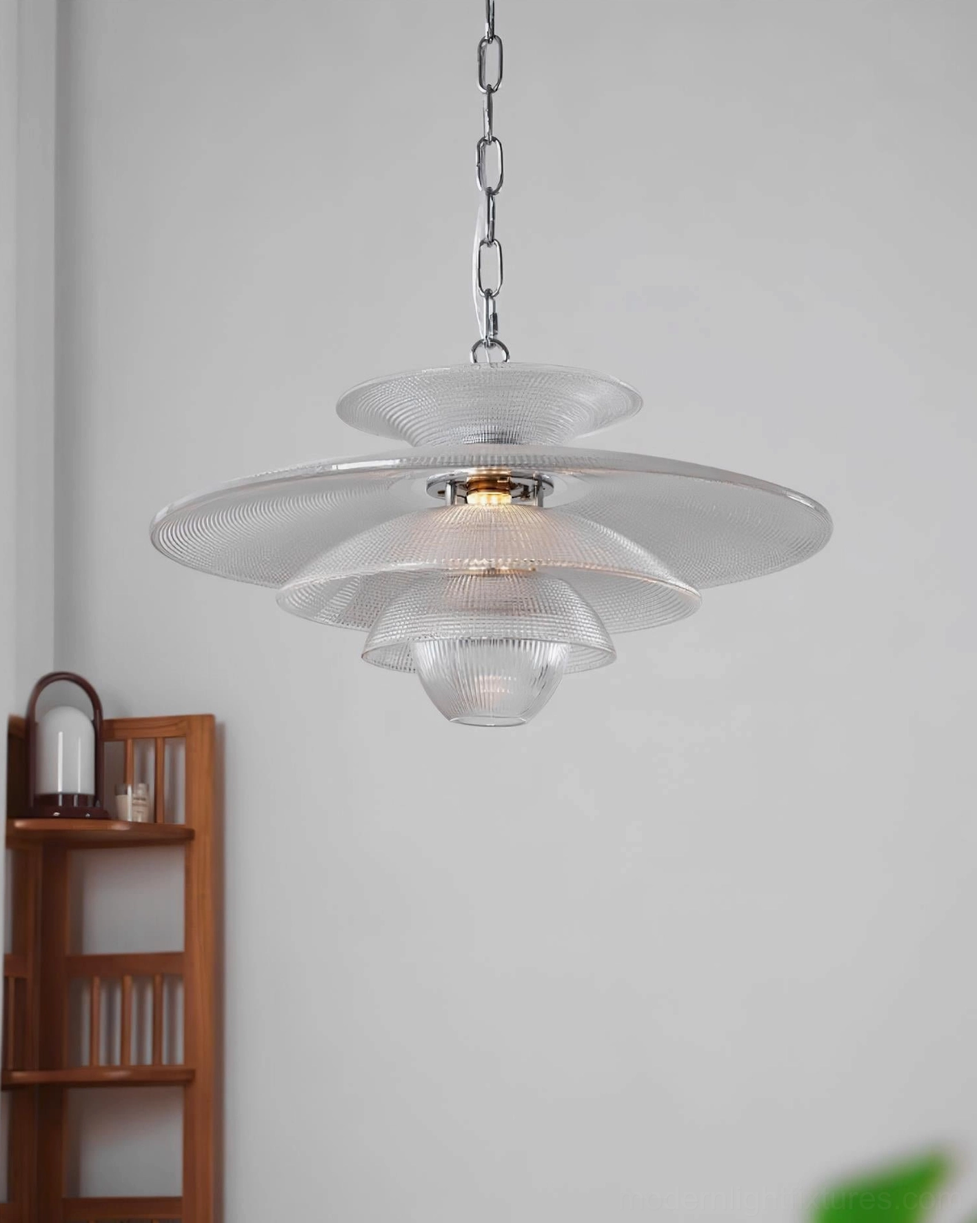 Cadenza modern glass pendant light with illuminated bulb displayed on wooden shelf, right-side view