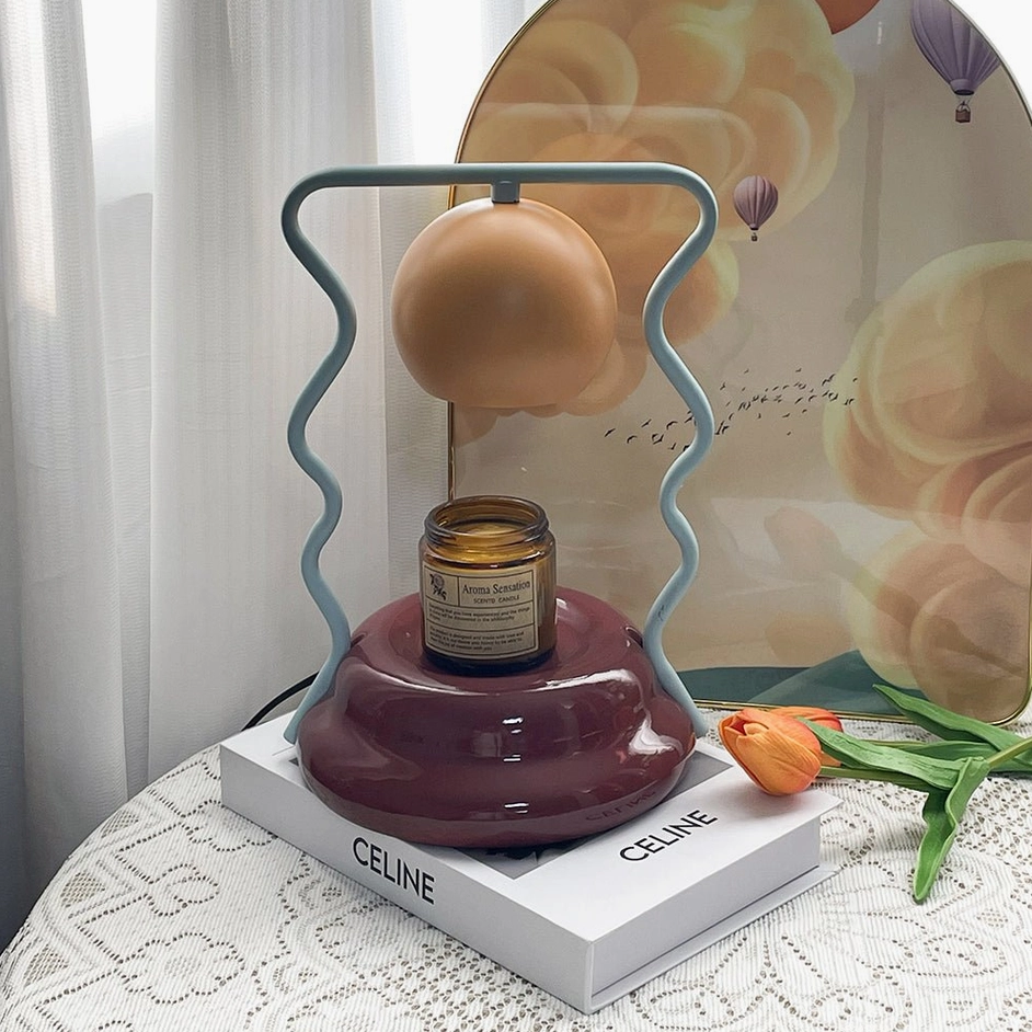 Caldas Candle Warmer Lamp on designer coffee table with art book - modern minimalist home décor