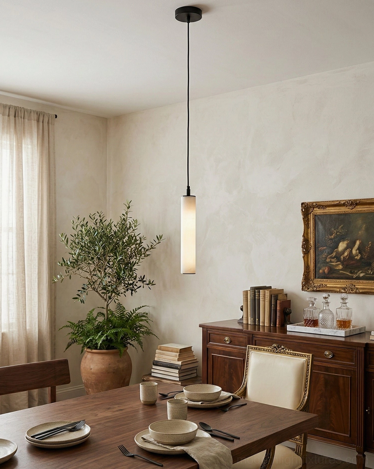 Modern dining area with calder alabaster tube pendant black hardware glowing warm light