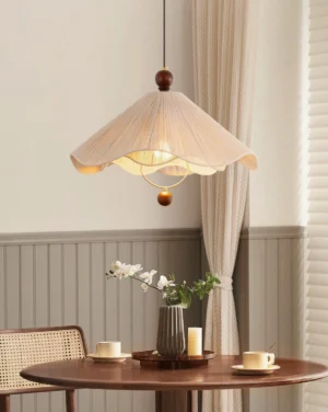 Calista pendant light hanging in modern dining nook, beige pleated shade with warm ambient glow, wooden wall detail