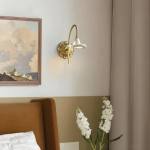 Vintage calla lily wall lamp installed in bedroom beside upholstered bed with warm ambient lighting and framed artwork