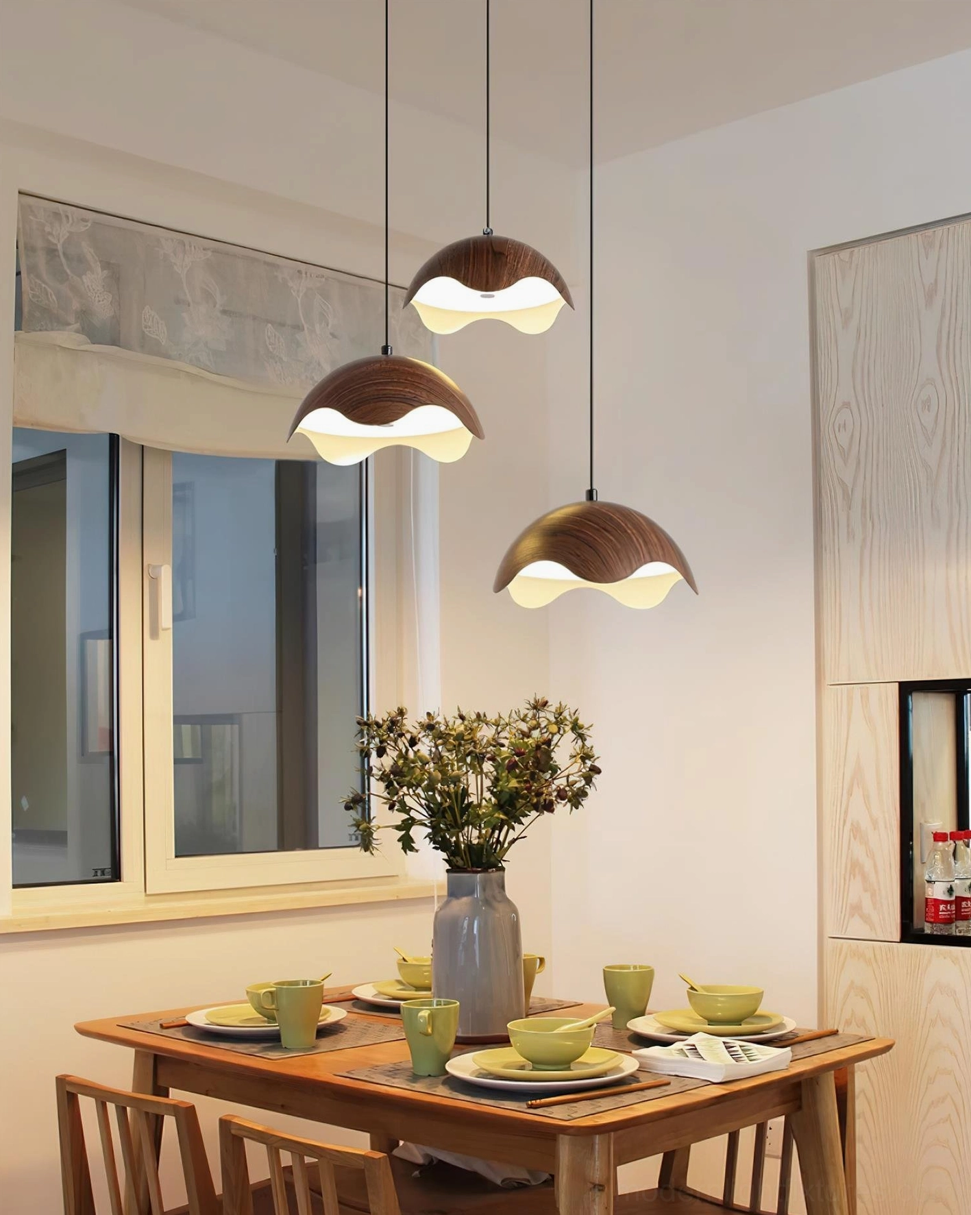 Callan 3-head asymmetrical pendant light set in contemporary home dining space with wooden grain shades and ambient lighting