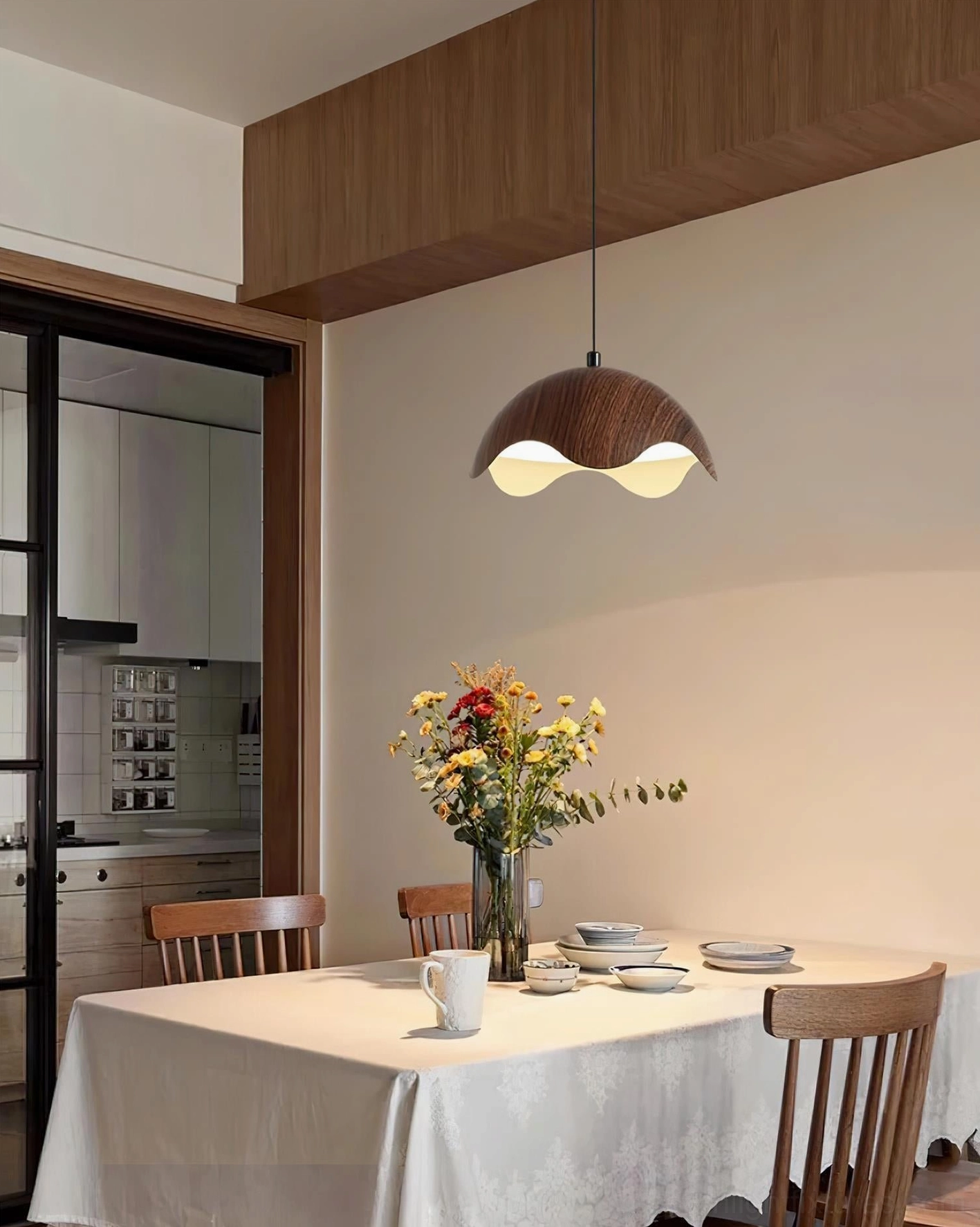 Single Callan organic wooden pendant lamp in kitchen dining room showing cozy rustic modern aesthetic and warm glow