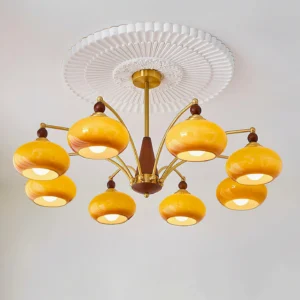 8-light vintage Calliope chandelier featuring amber glass dome shades, brass finish metal arms, and wood body components - studio lighting fixture view