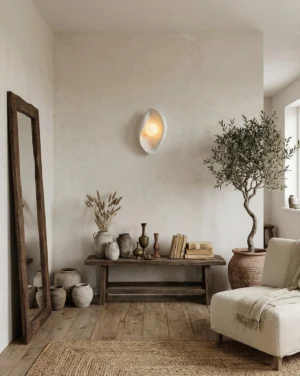 Callora wall sconce in wabi-sabi living room setting, soft curved design casting gentle shadows on neutral wall