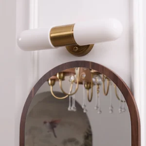Calvero wall lamp installed above arched vanity mirror bathroom lighting design