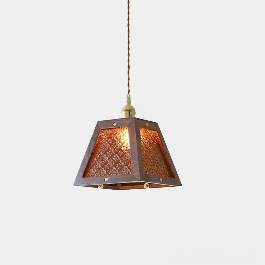 Calvi vintage glass pendant lamp with amber embossed shade and dark wood frame, frontal view against white wall