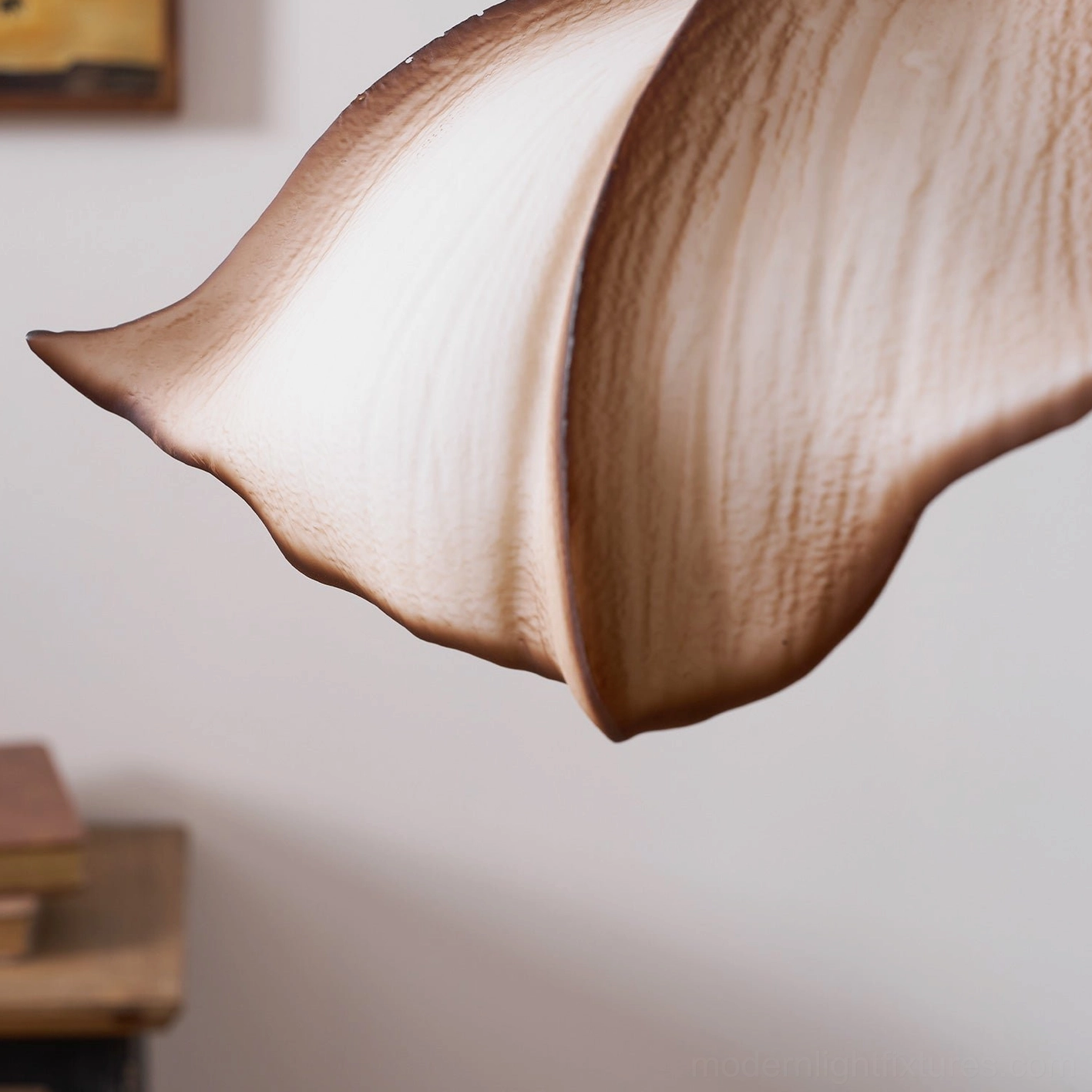 Calysa petal pendant fixture creating soft diffused glow in minimalist modern bedroom or reading nook setting
