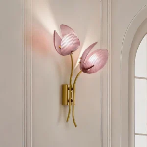 Calyssa wall sconce in soft pink with ribbed glass shades mounted on wall, three-quarter perspective showing architectural installation