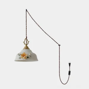 Camellia Grace plug-in ceramic pendant light with white glazed porcelain dome shade and sculptural camellia floral relief, brass socket, and twisted brown braided cord on white background