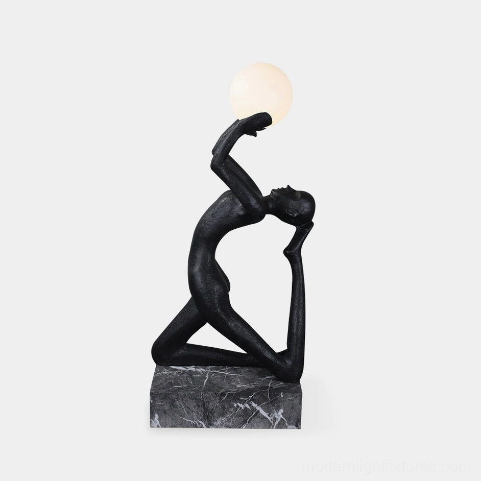 Camilla kneeling sculpture floor lamp front view with matte black resin figure and frosted glass orb on marble base
