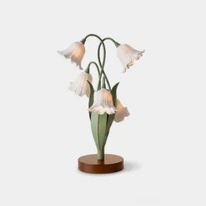 Campelle floral table lamp with white bell-flowers on green iron stems and walnut wood base, front view against white studio background