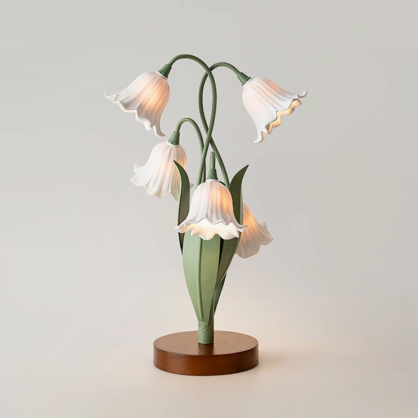 Campelle white bell-flower table lamp front three-quarter view showing pleated acrylic petals, green stems, and walnut base against white background